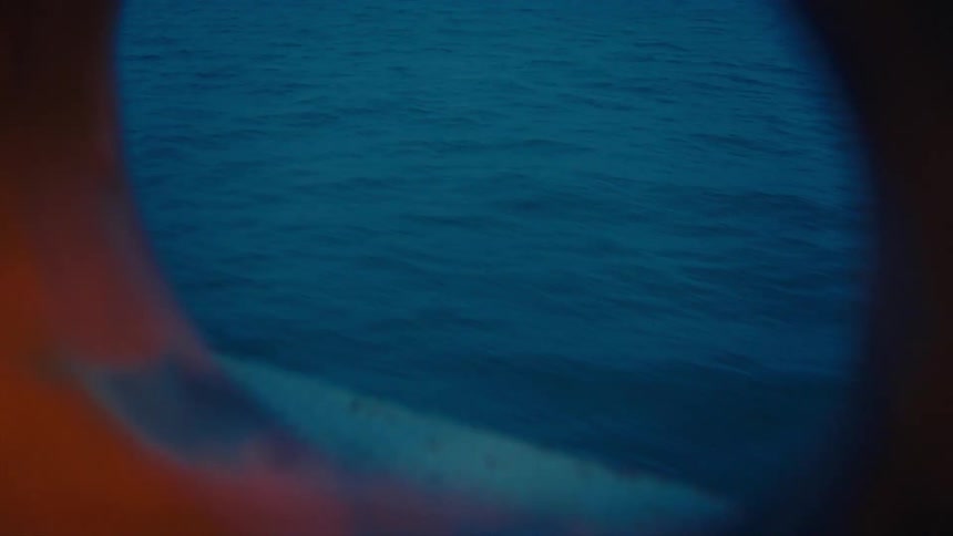 A view of a vibrant view ocean seen through a porthole