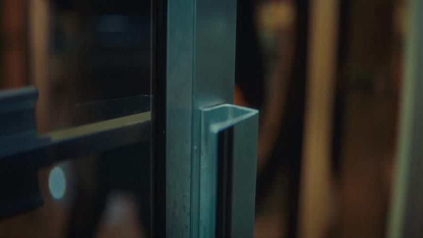 An up close look at a building door as a person opens the door as goes inside and opens another door