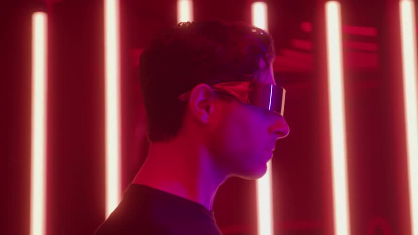 Man wearing a reflective visor in an environment lit by red lights