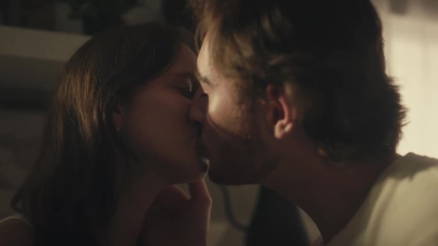 Man and a woman smile at each other after kissing and then the man kisses the woman on the nose
