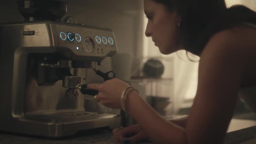 Person adjusting the portafilter on an espresso machine