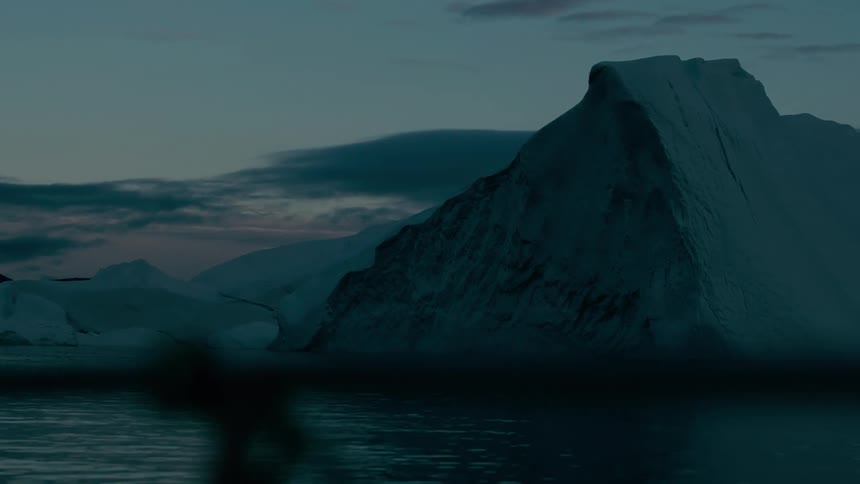 Giant iceberg over calm waters at dusk