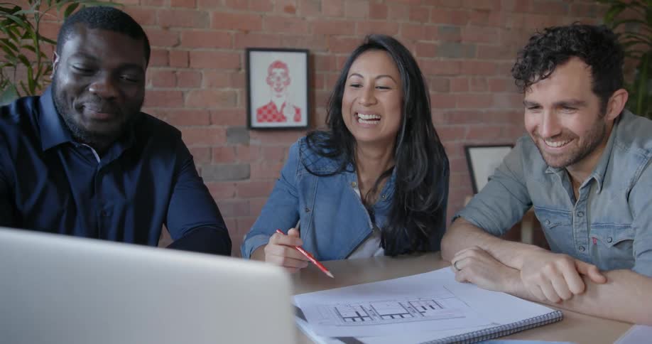 People talk together smiling in a conference room