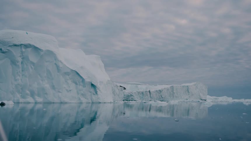 Glacier and pieces of melting ice floating on arctic water