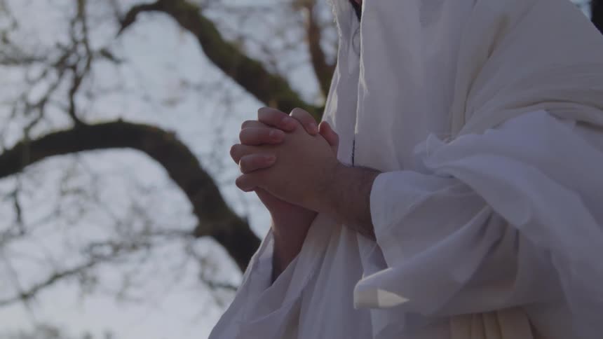A religious priest praying outdoors during daytime
