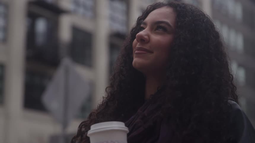 A woman smiles while looking at something behind the camera