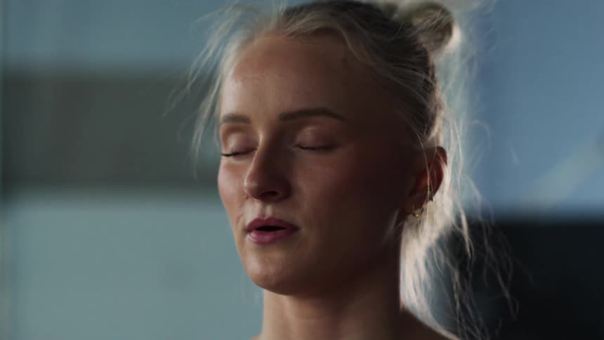 Close up portrait of a young woman meditating in a room during daytime