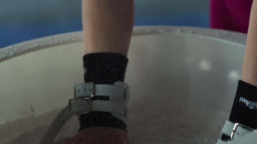 Hand collecting magnesium powder inside a chalk bowl