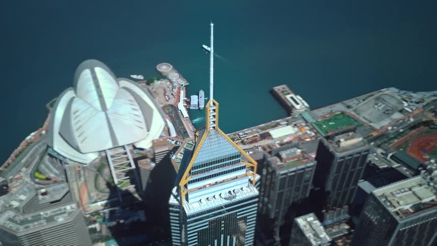 A Timelapse of Distinctive Skyscraper With a Pointed Glass and White Shell Structure Near a Large Body of Deep Blue Water in the Business District in Hong Kong Asia
