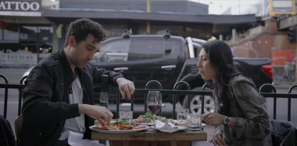 A man and woman eat outside