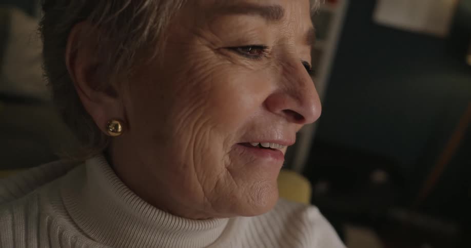 The woman laughs while holding her cell phone up