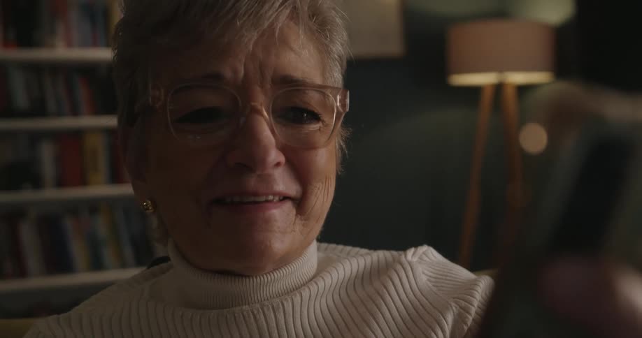 Close up portrait of an elderly woman on a mobile video call while sitting in a room