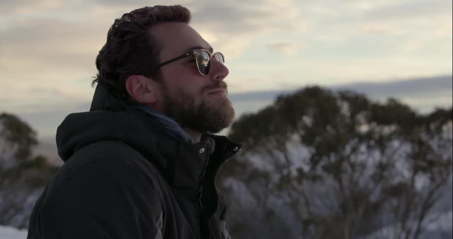 A man uses a phone in the mountains