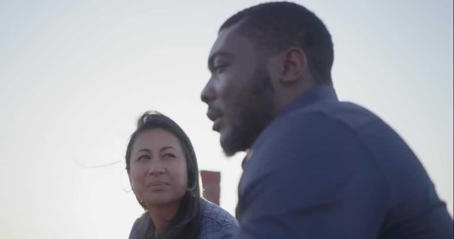 A man and woman talk on a windy day
