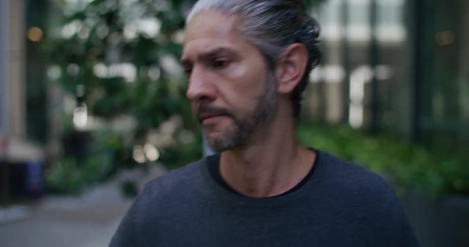Older man approaches a car parked downtown during the day and reaches for the door
