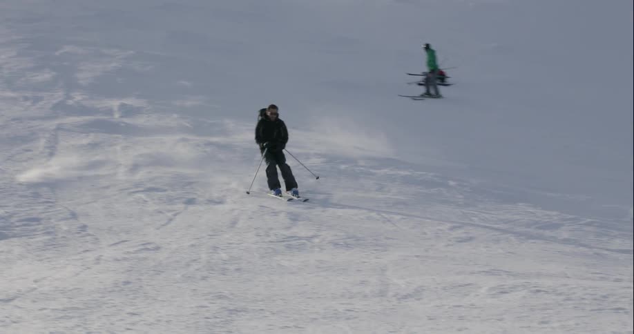 A man skis down a snowy mountainside