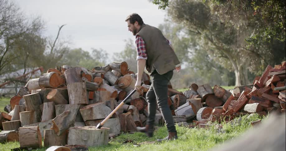 A man uses an axe to chop wood