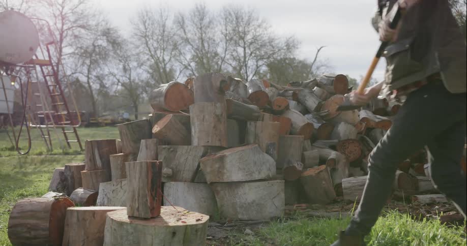 A man puts a log down to chop