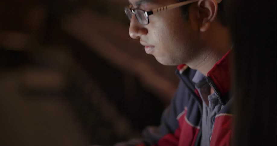 A man and woman talk over a laptop