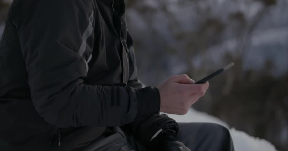 A man looks at his phone and laughs