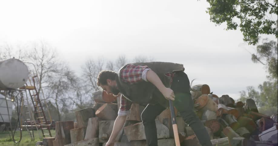A man cuts a log with an axe
