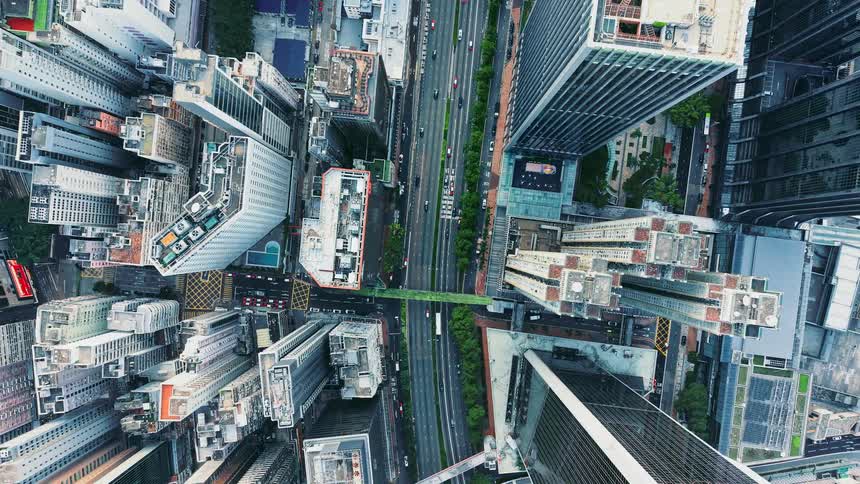 Skyscrapers and urban roads seen from above forming a dense pattern of blocks and traffic