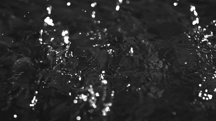 A view of rain drops falling onto water