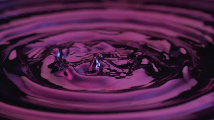 Purple liquid forming multiple raised splashes after impact