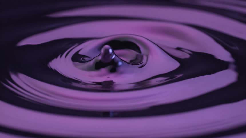 Purple liquid surface forming small elevations after displacement