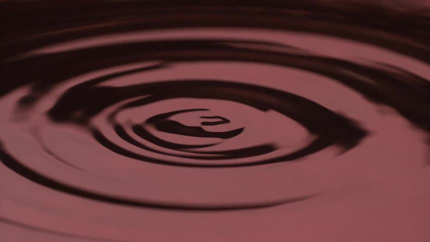 Red liquid surface with protrusions formed by impact