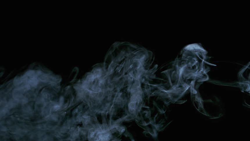 Light shines on white smoke as it moves across the darkness and fades away