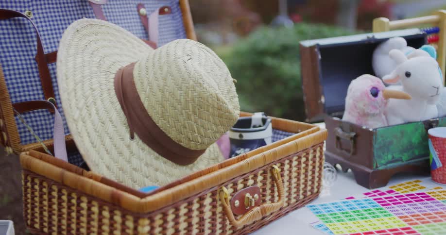 Straw hat and stuffed toys arranged in baskets on an outdoor table