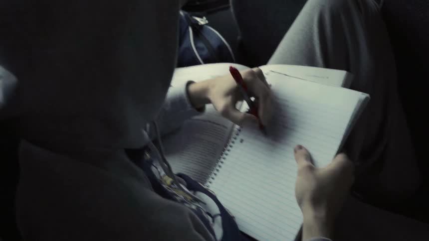 A man is writing in a notebook