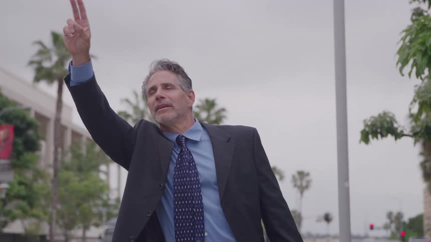 The man is hailing a taxi