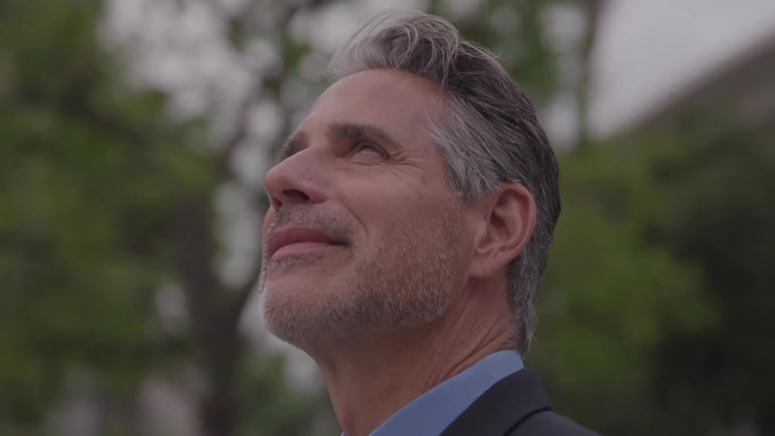 The man is looking up and smiling