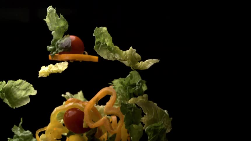 Some salad ingredients falling through the air