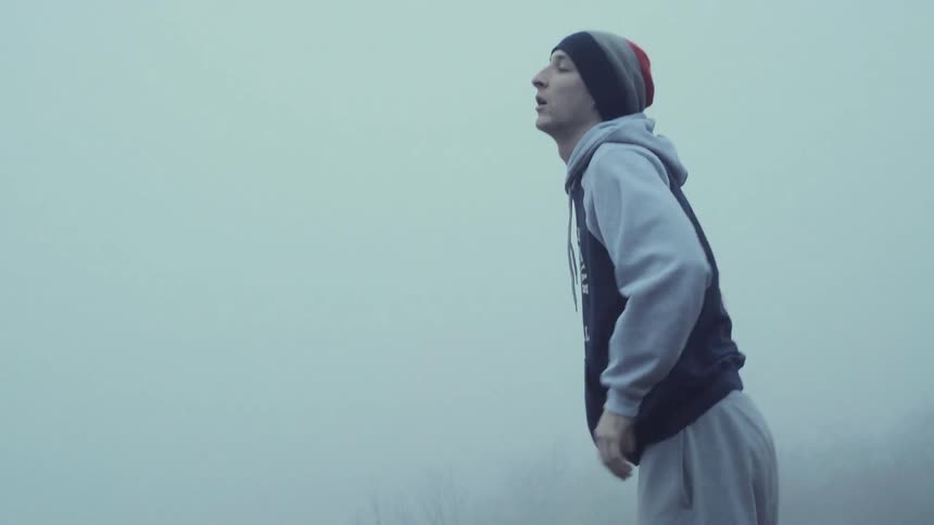 A jogger stops for a break outside on a foggy day