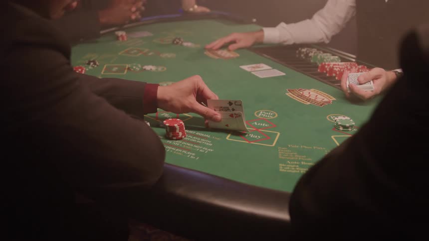 Player holding a card over a casino table