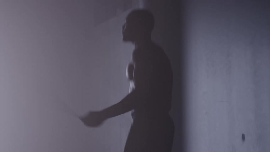 Person skipping rope indoors with foggy atmosphere and dramatic lighting