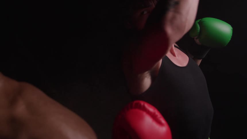 Two men are boxing against a black background
