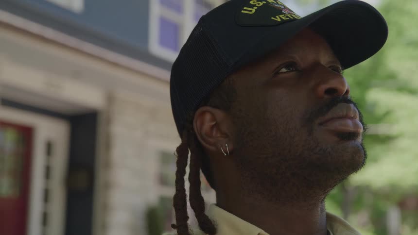Man wearing a veteran cap looking upward