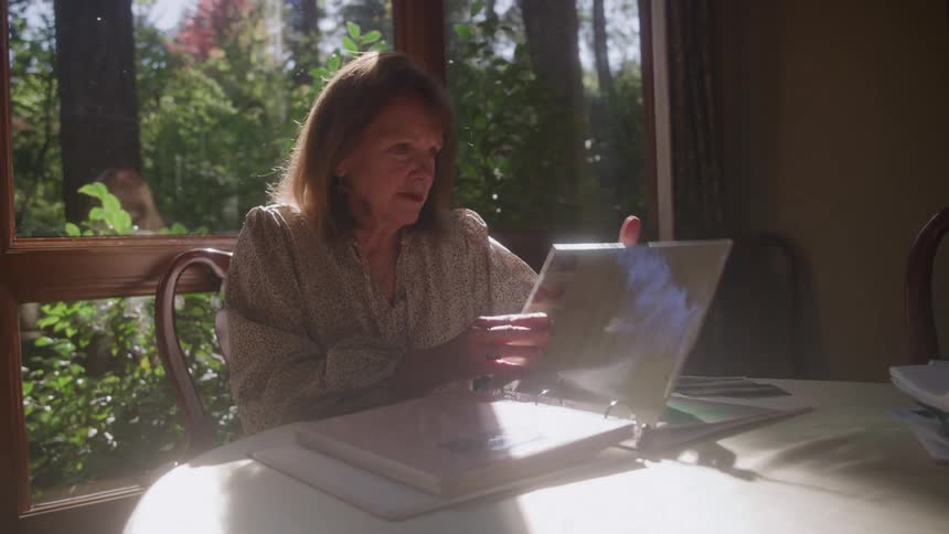 Woman sitting at the table flipping through a binder