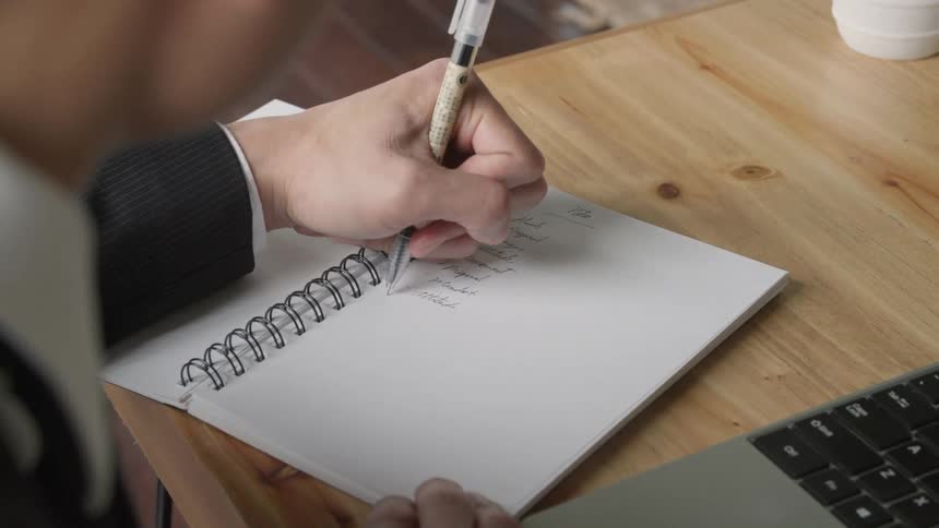 A person writing in a noteboook