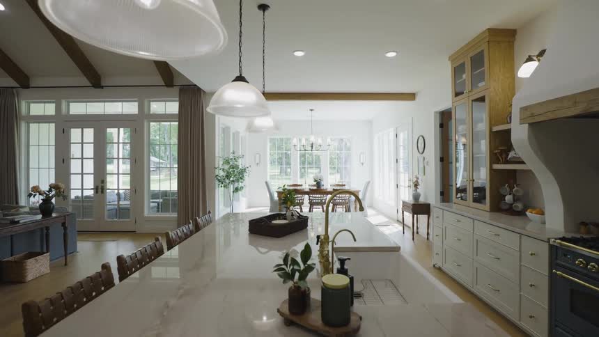 Modern farmhouse kitchen with marble island pendant lights and sunlit dining table