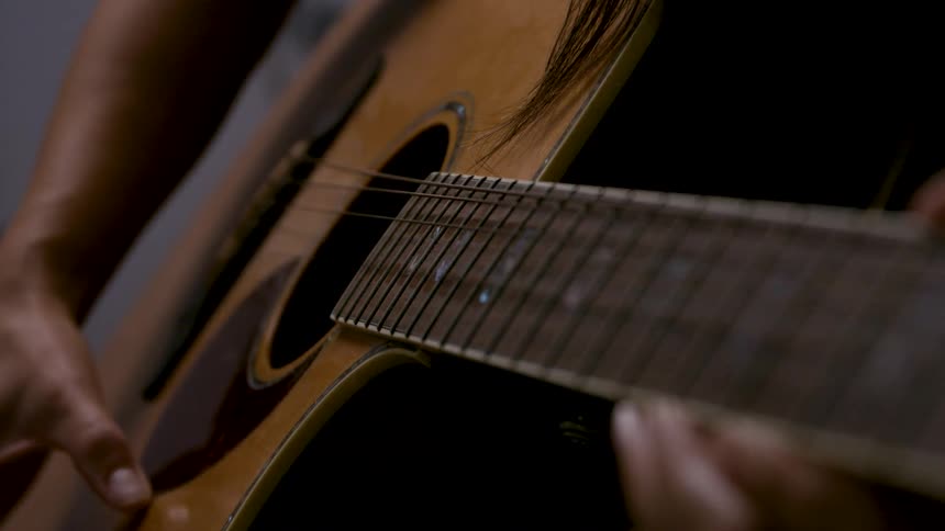 A person strumming guitar strings