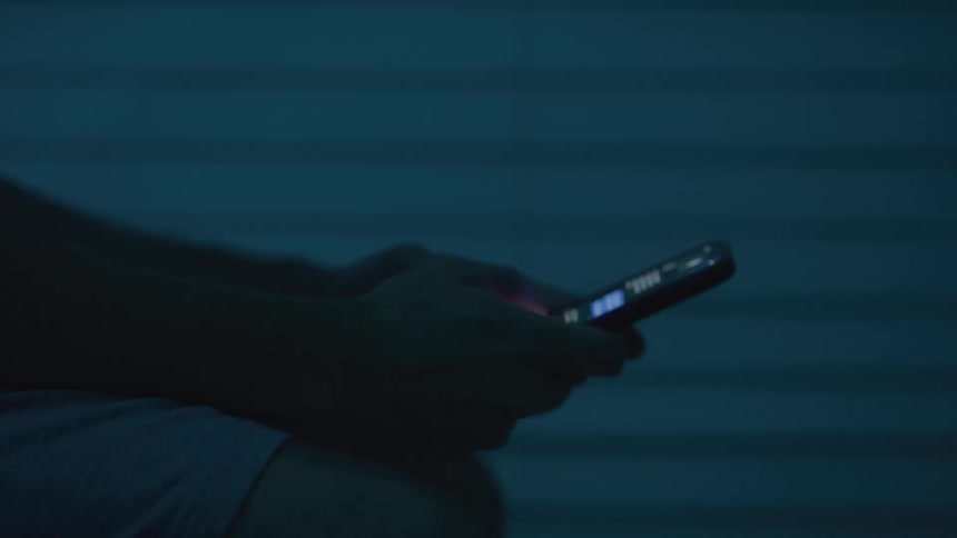 Man holding his phone and texting with his thumbs