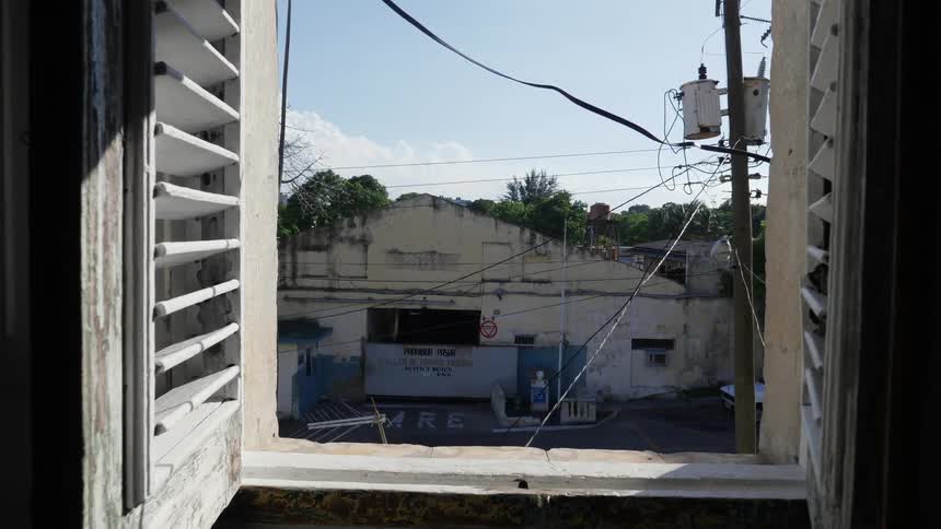 Looking out of a window at an abandoned looking building