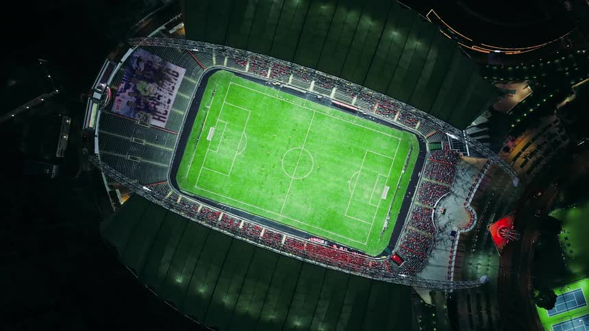 Aerial view of a soccer stadium as spectators in the stands watch the teams of players on the field