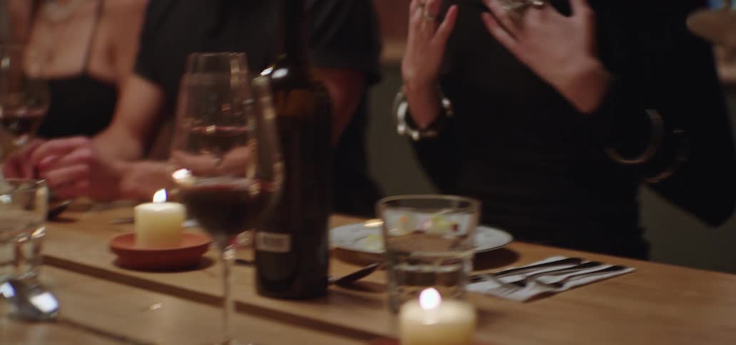 Man wearing an apron serves the guests at a dinner party