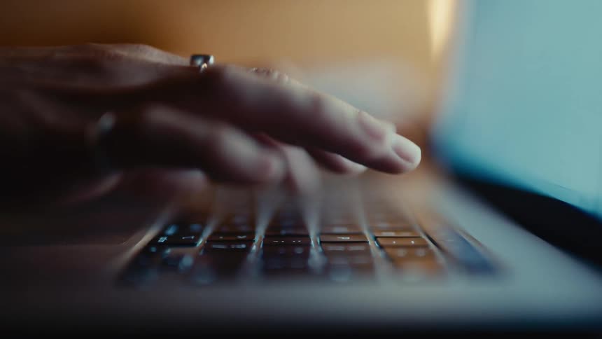 Fingers typing on a laptop keyboard